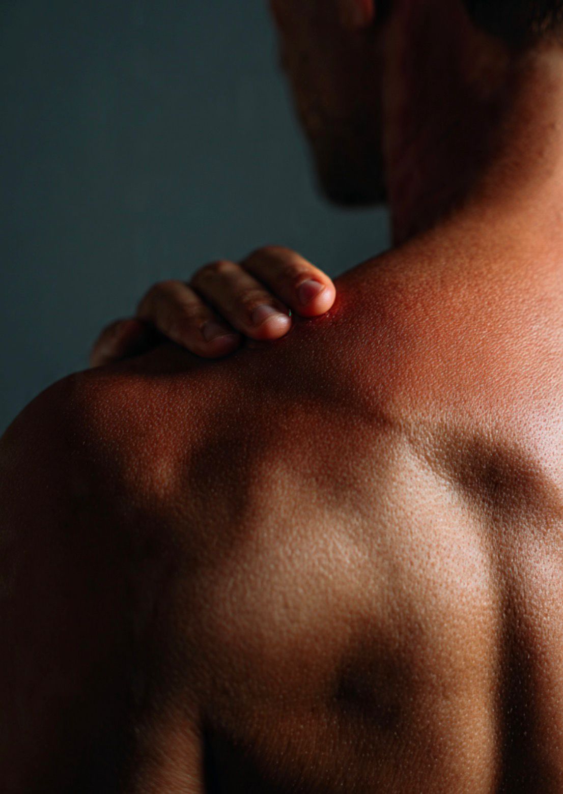 Person demonstrating pendulum exercise to improve range of motion in frozen shoulder (adhesive capsulitis) treatment.
